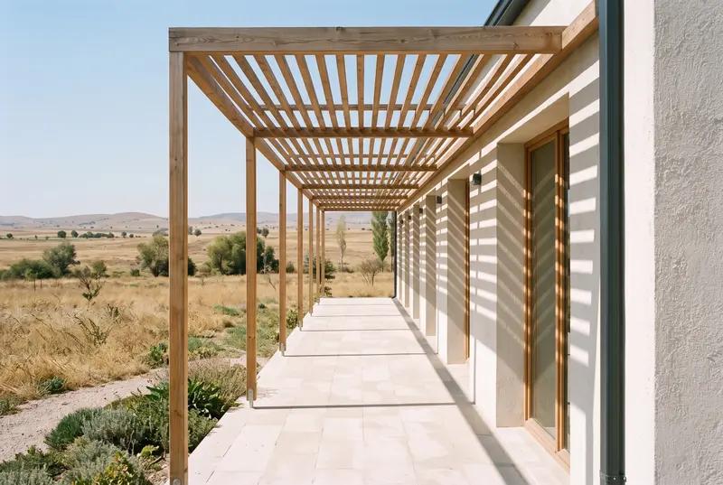 Ahşap pergola altında taş kaplı teras. Sağda derin nişli ahşap doğramalı pencereler, zeminde çizgili gölgeler. Temsili görselleştirme.
